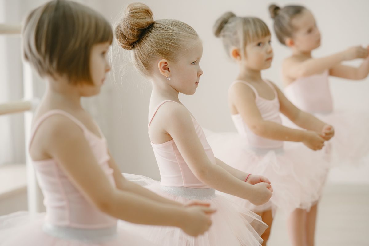 Young dancers lined up at the ballet barre